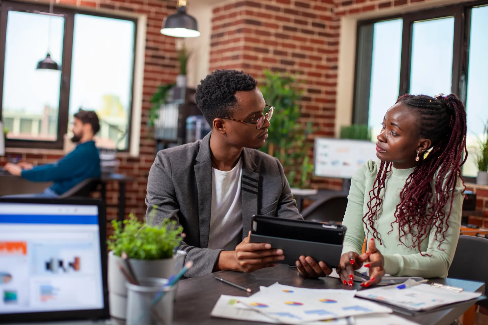 Two colleagues reviewing a business plan together at a desk