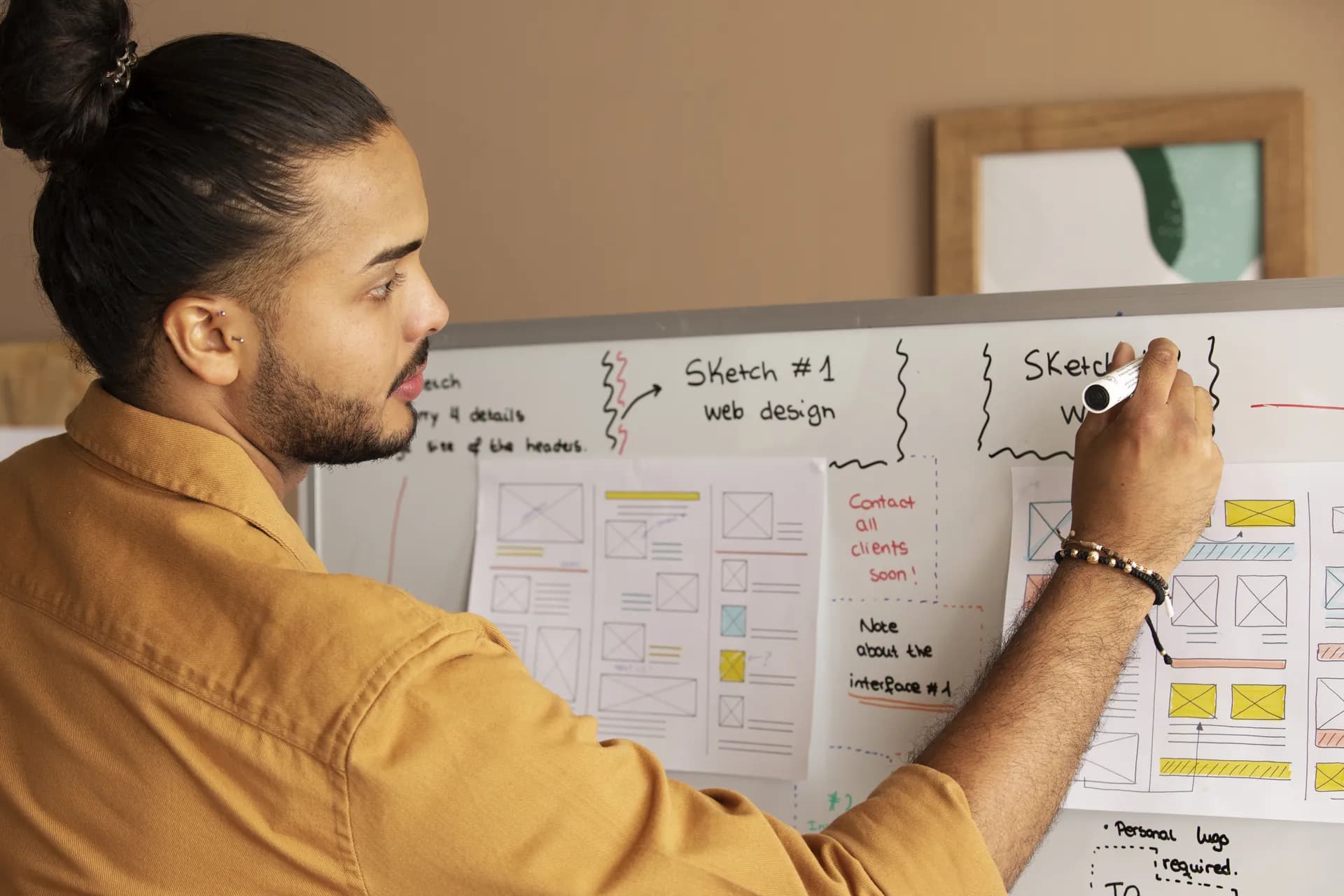 Designer sketching website wireframes on a whiteboard