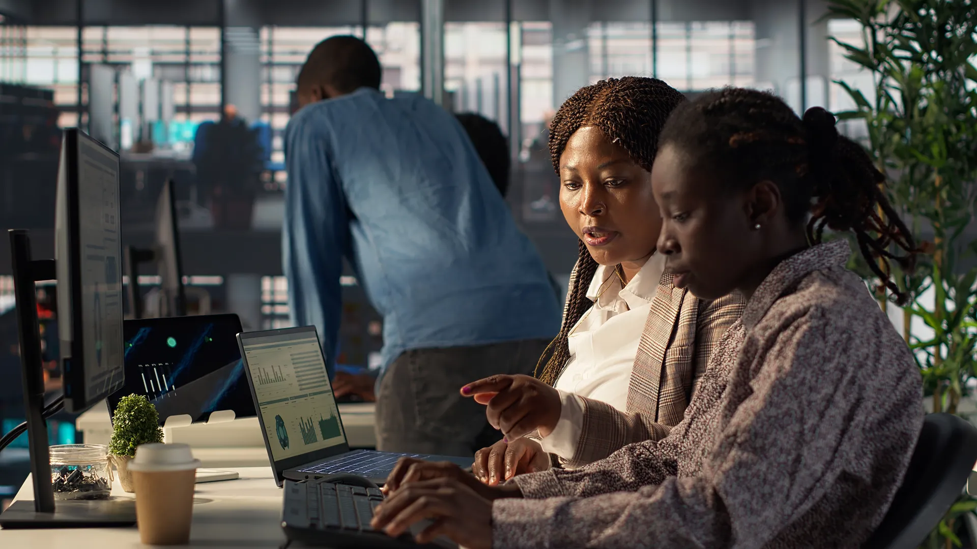 Team of colleagues working together at computers in a modern office